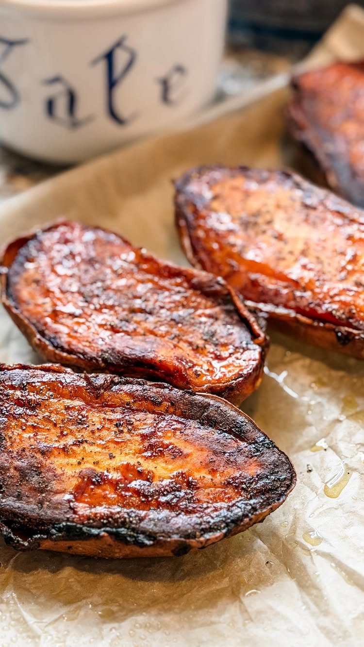 Roasted sweet potato slices with caramelized edges on brown parchment paper.