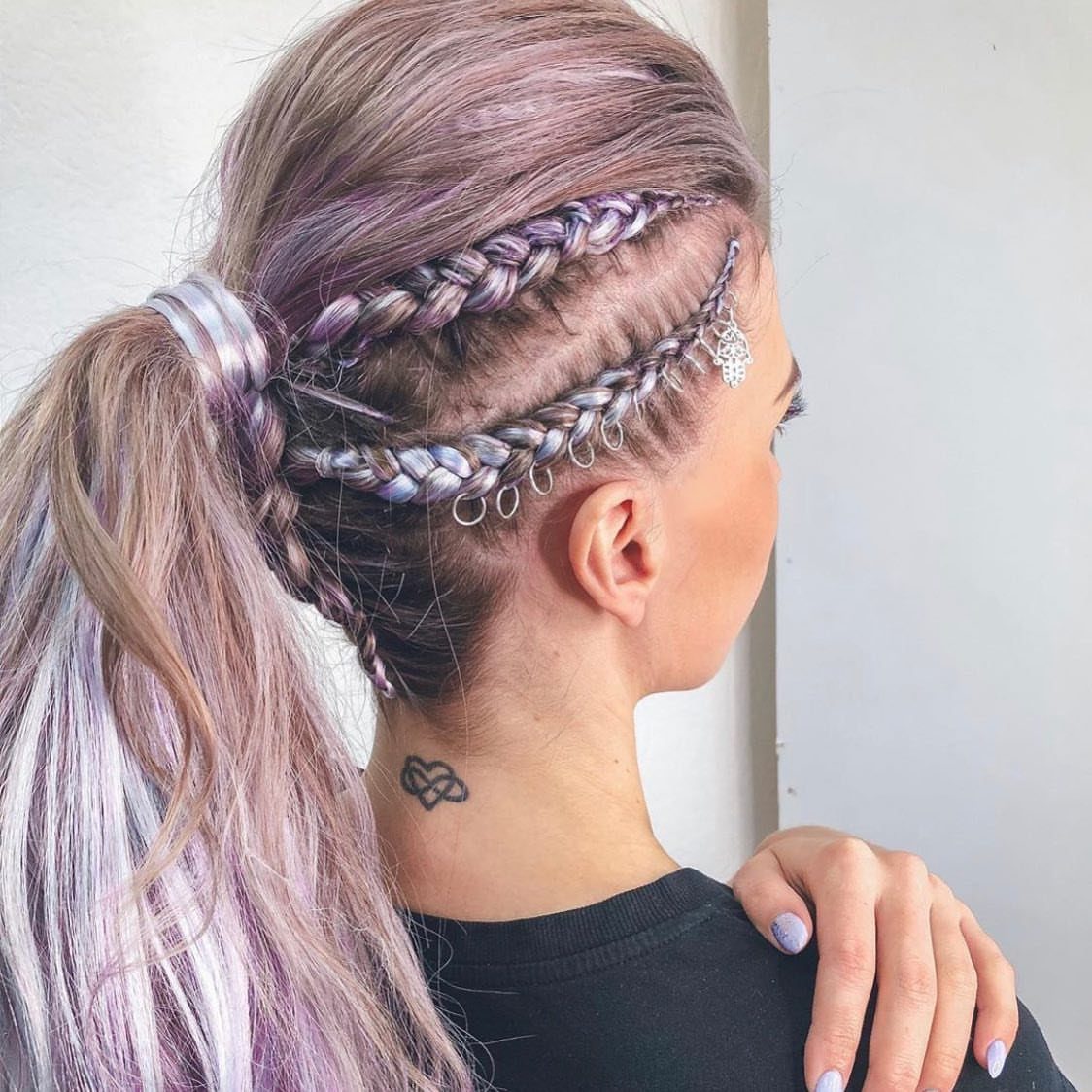 Purple and silver hair in cornrow braids with silver ring charms in a ponytail.