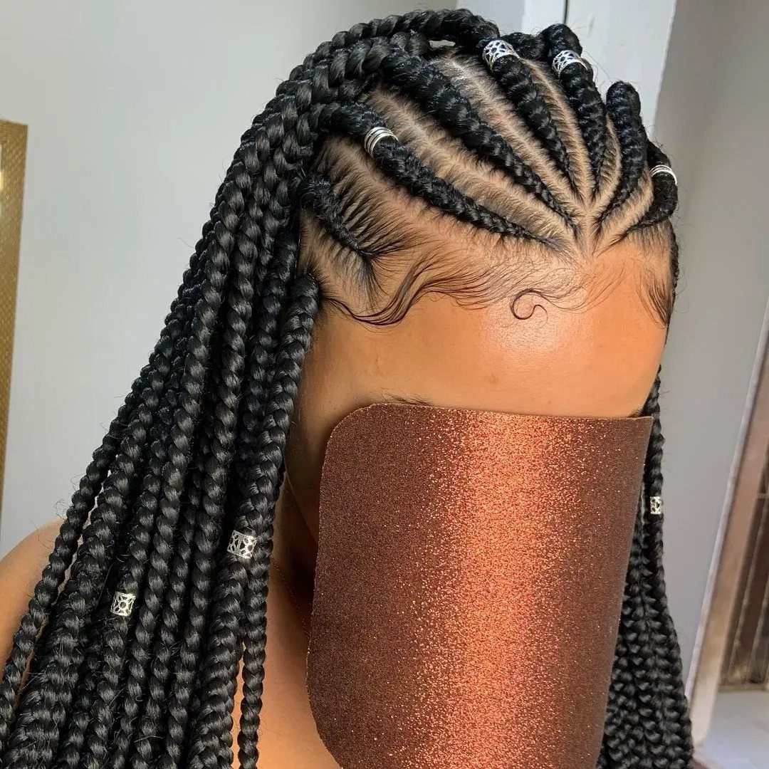 Fulani braids with cornrows at the front and long braids with silver beads.