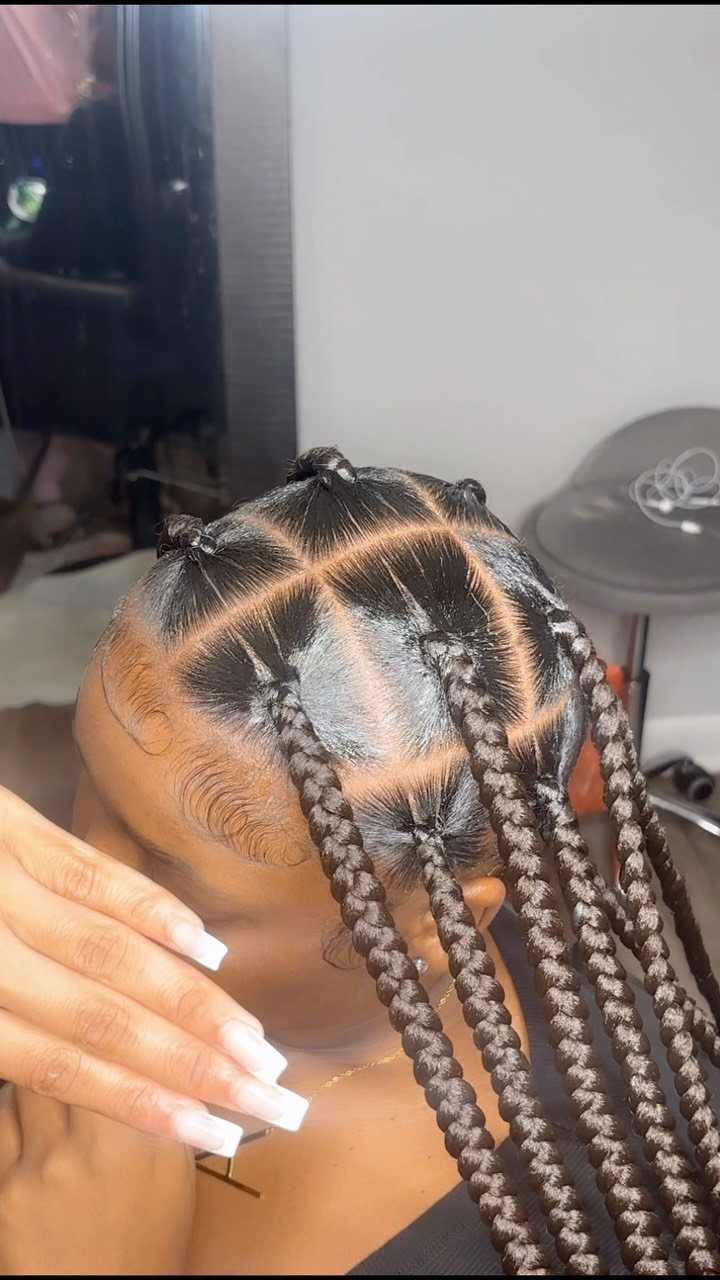 Jumbo box braids with clean square parts on a person's scalp.