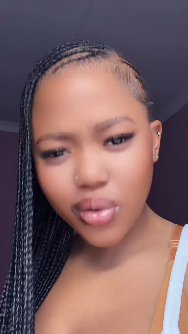Woman with side-swept lemonade braids curving across her scalp and falling to one side.