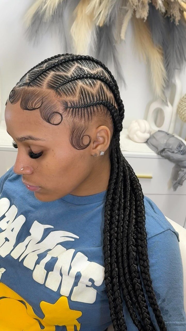 Woman with stitch braids on her scalp and long black braids hanging down.