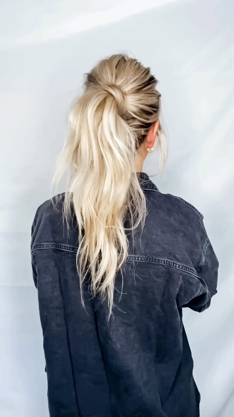High textured blonde ponytail on a person wearing a dark grey denim shirt
