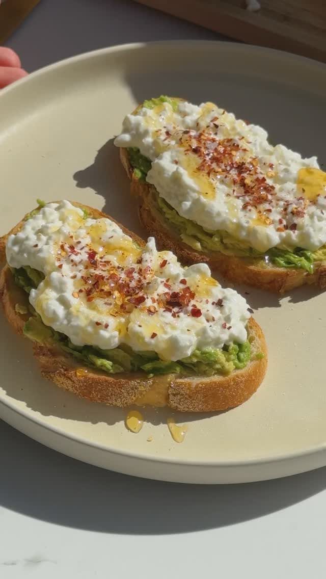 Avocado toast topped with cottage cheese and red pepper flakes on a plate