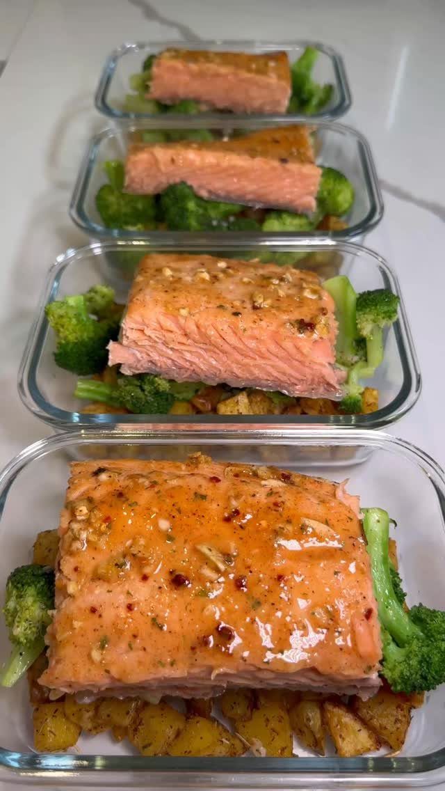 Salmon fillets with broccoli and roasted potatoes in glass meal prep containers.