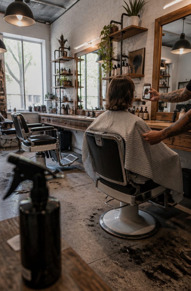 Barber discussing a longer hairstyle with a client during a trim