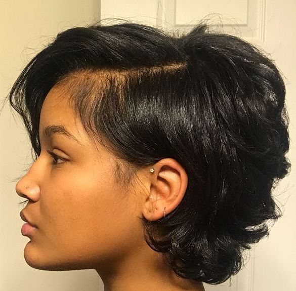 Person with short black hair featuring side-swept bangs and voluminous layers.