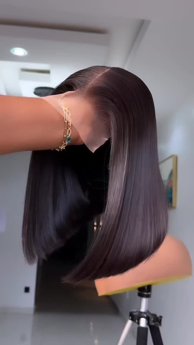 Mannequin head with a sleek dark brown wig showing a realistic scalp line.