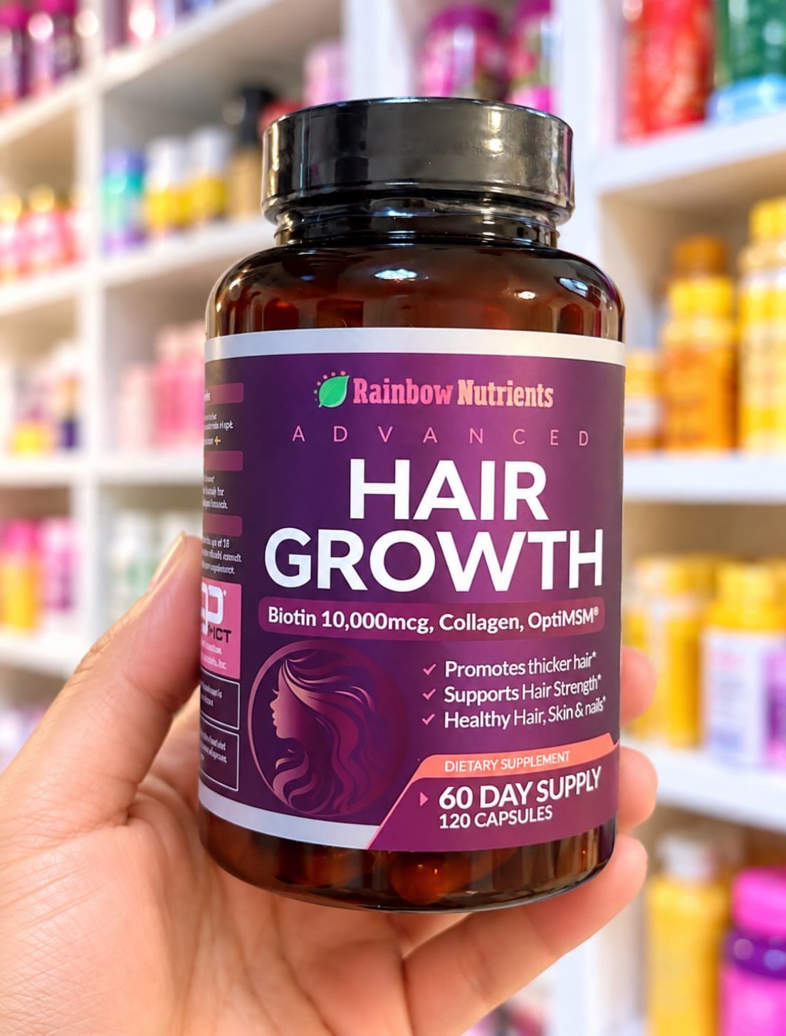 Biotin hair growth supplement bottle held in a hand inside a supplement store.