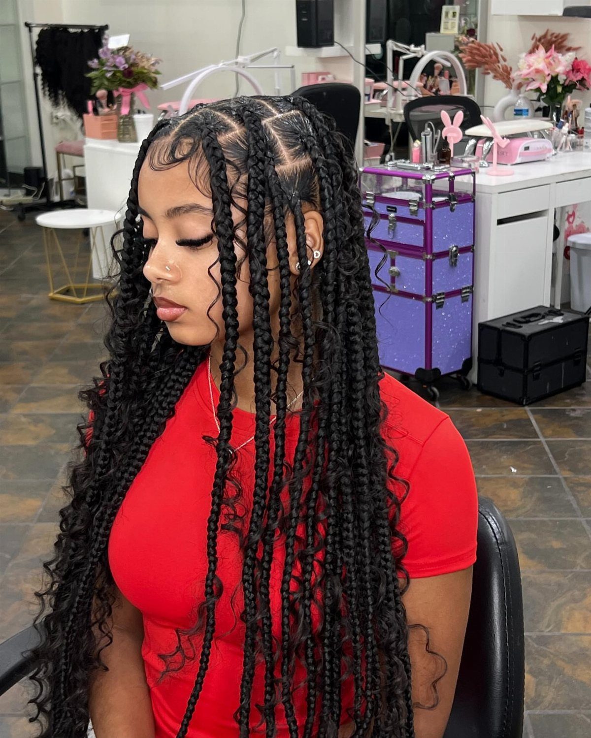 Woman with big-little goddess braids featuring large and small cornrows and curly ends.