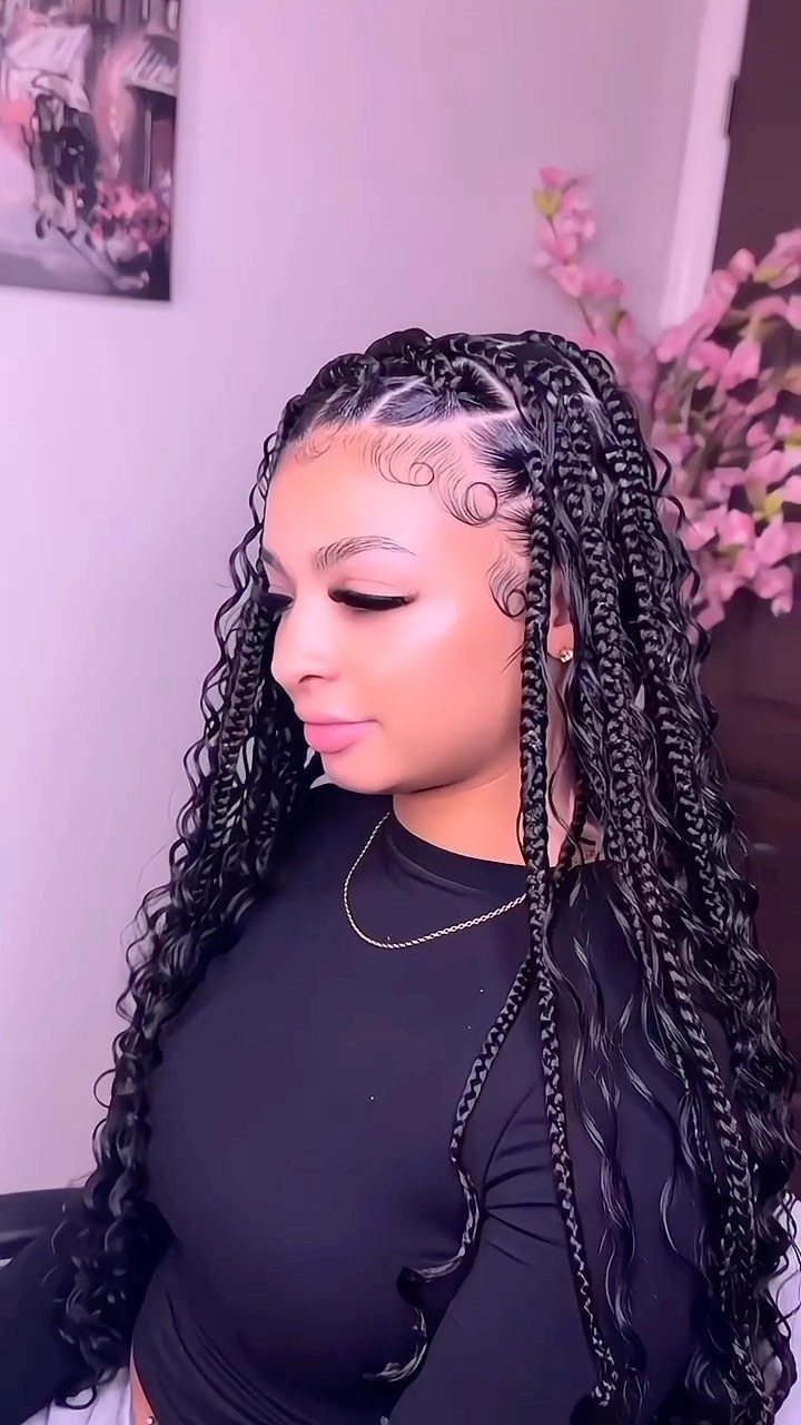 Woman with long black boho box braids and curly loose hair strands.