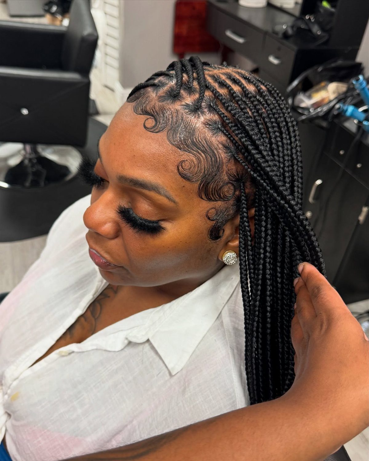Woman with black box braids divided into square sections on her scalp.