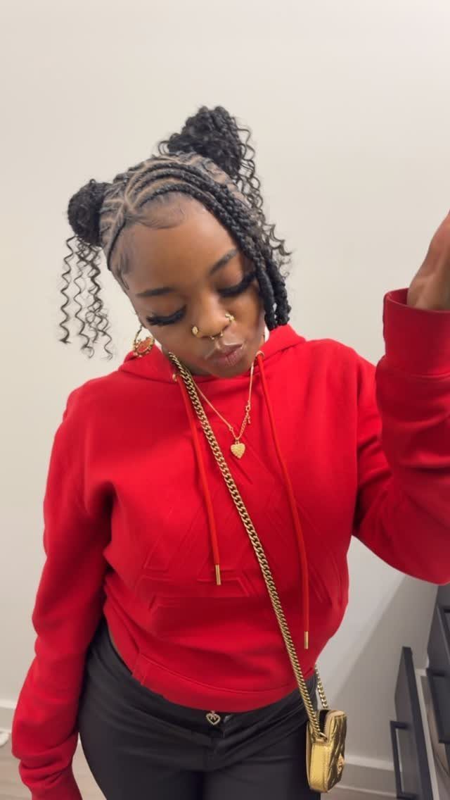 Woman with two braided buns on top of her head and curly ends.