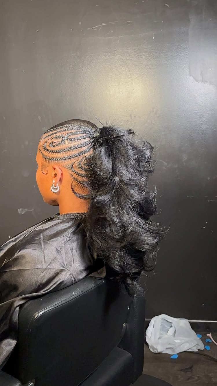 Intricate scalp braids gathered into a high, voluminous curly black ponytail.