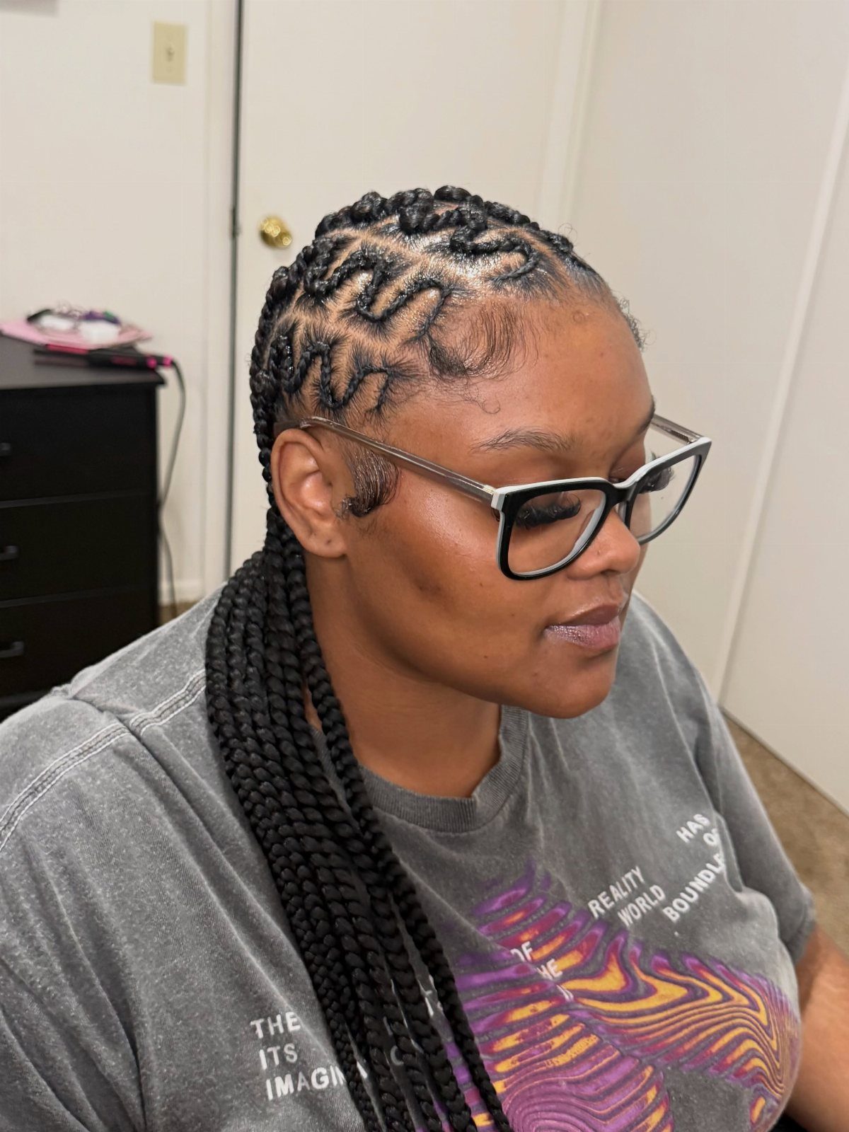Woman with large curving cornrow braids forming a pattern on her scalp.