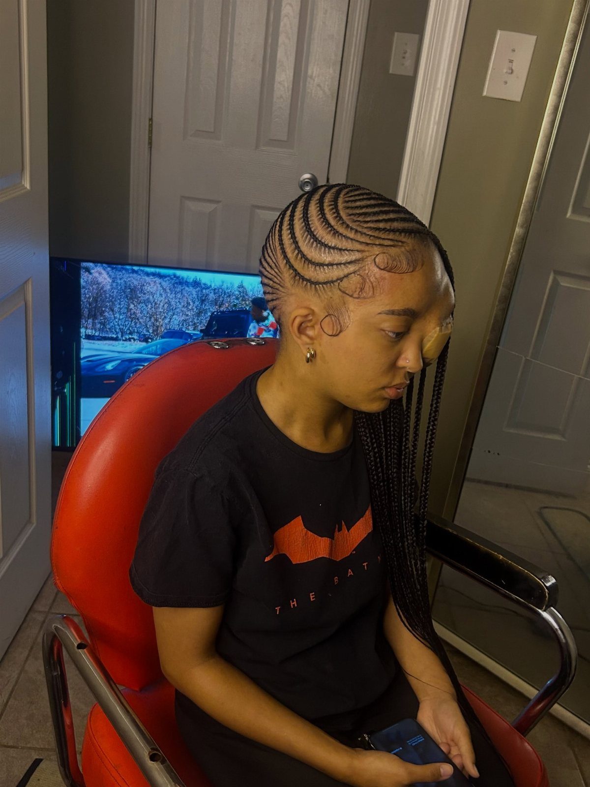 Person with side-swept lemonade braids curving across the scalp and hanging over one shoulder.