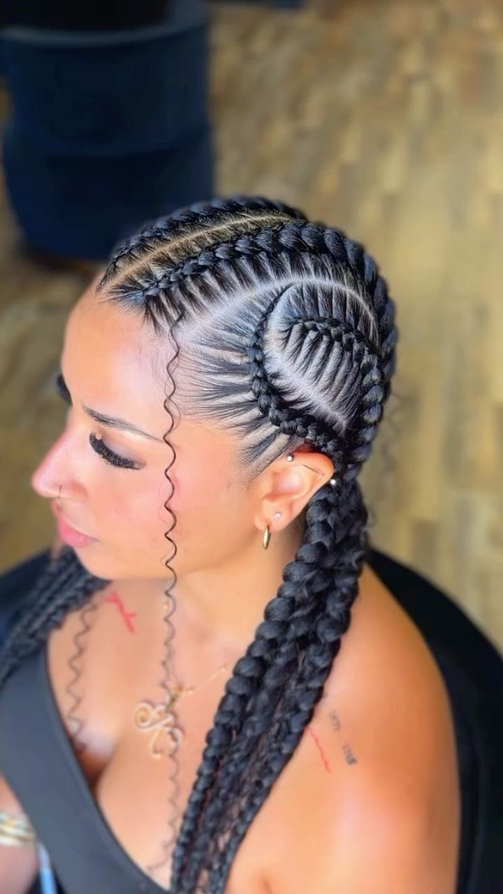 Woman with dark hair styled in intricate stitch braids with a circular pattern.