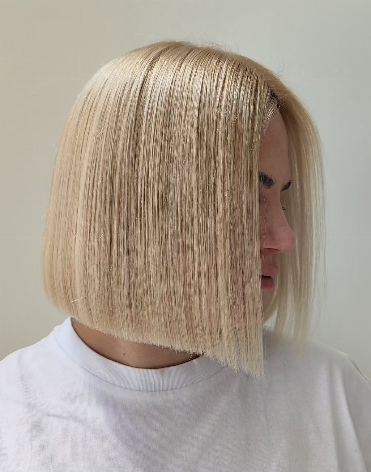 Blonde sleek A-line bob haircut with straight hair and angled length.