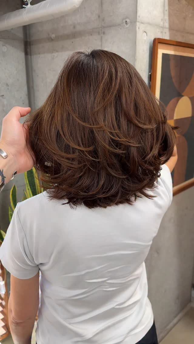 Mid-length reddish-brown hair with voluminous layers viewed from the back.